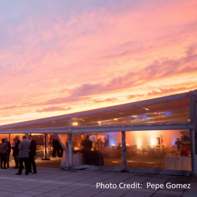 Guests gather for a rooftop reception under a glowing sunset sky in Washington, DC.
